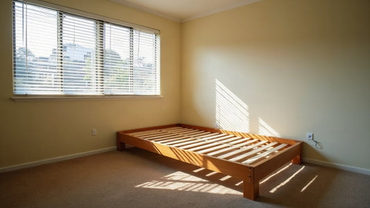 Empty Sydney rental bedroom with a bare timber slat bed base and the mattress removed
